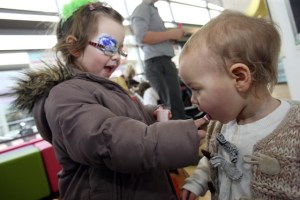 baby being fed by her sister