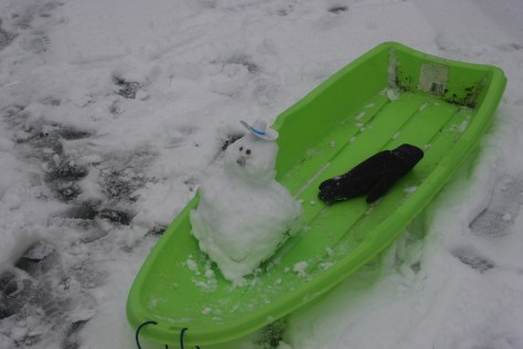 baby snowman on sledge
